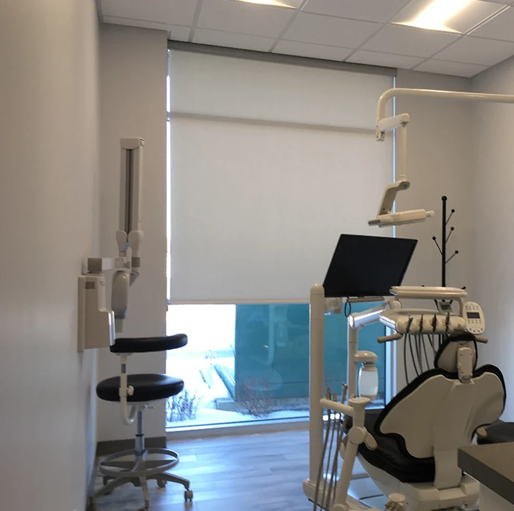Roller shades beside a dental treatment chair
